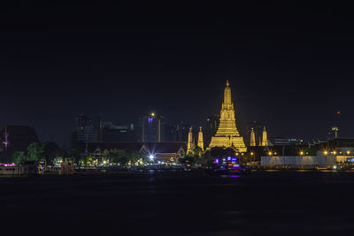 Illuminated buildings against sky at night