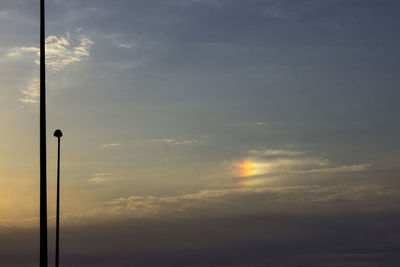 Low angle view of street light against dramatic sky
