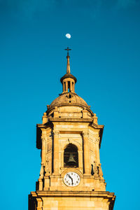 Low angle view of clock tower against blue sky