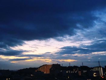 Silhouette buildings against sky at sunset