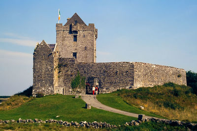 Woman standing in front of fort against sky