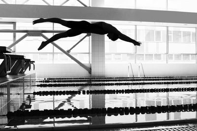 Silhouette woman jumping in swimming pool