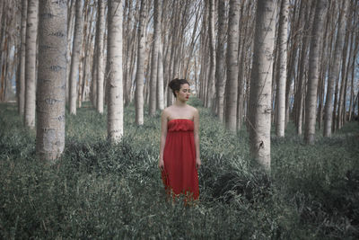 Young woman standing at forest