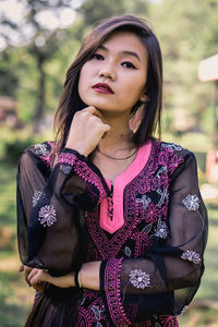 Portrait of beautiful young woman standing outdoors