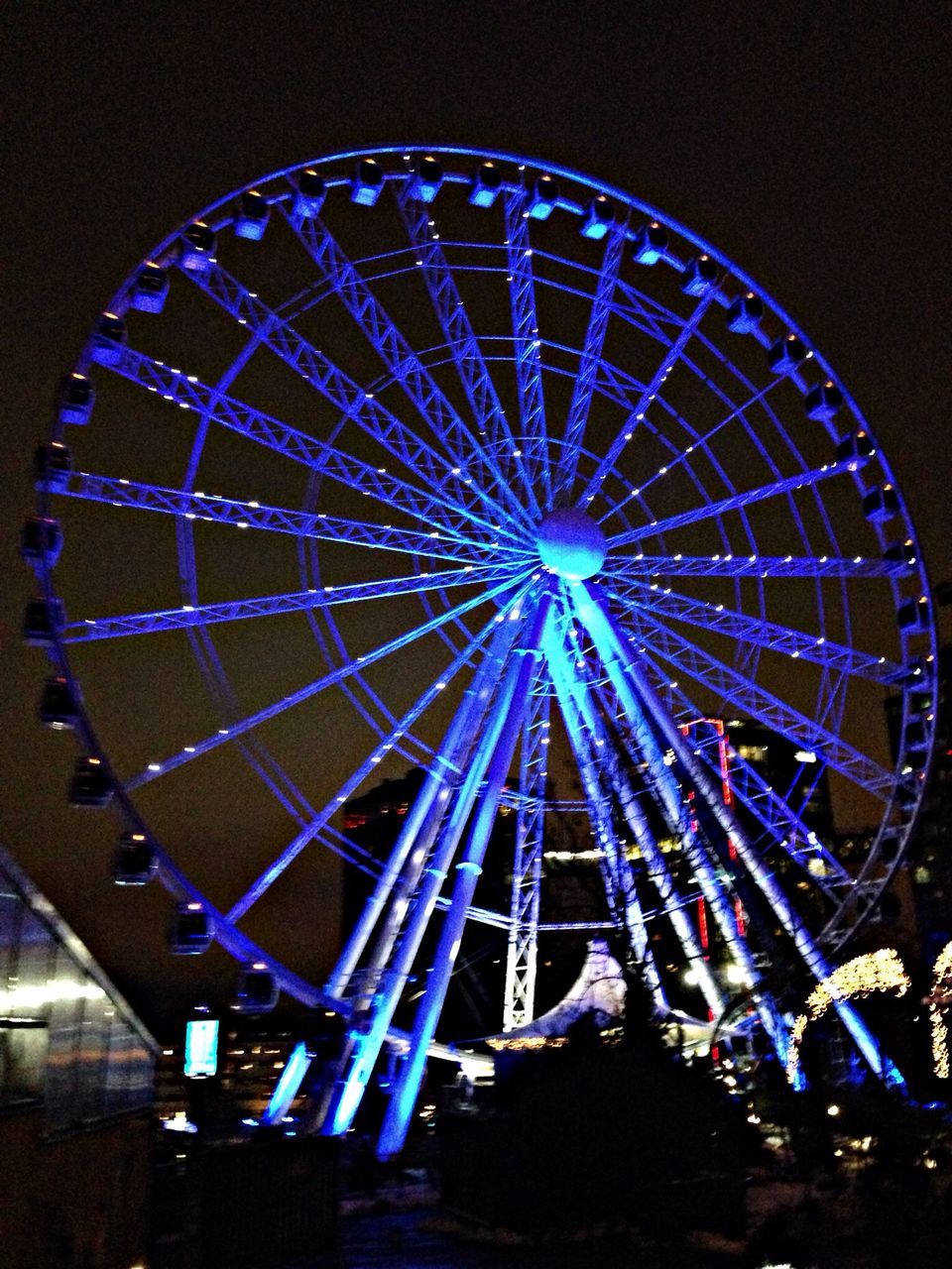 illuminated, night, amusement park ride, ferris wheel, amusement park, arts culture and entertainment, low angle view, lighting equipment, circle, multi colored, clear sky, sky, glowing, decoration, no people, built structure, geometric shape, outdoors, celebration, light - natural phenomenon