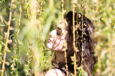 Woman looking away on plant at field