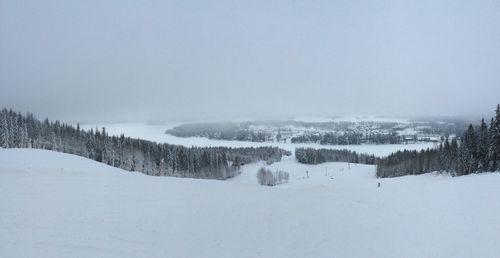 Snow covered landscape against clear sky