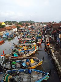 High angle view of boats moored in river against buildings in city