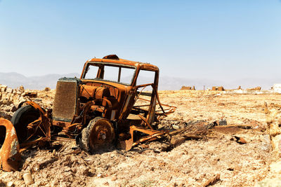 Old machinery on field against clear sky