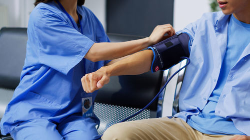 Midsection of doctor examining patient in hospital