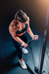 Side view of young woman exercising at gym