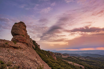 Rock formations on landscape against sky during sunset