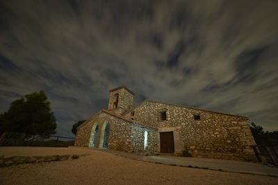 Low angle view of old building against sky at dusk