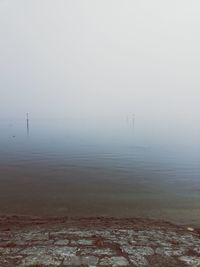 Scenic view of lake against sky during foggy weather