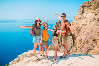 People standing on rock against sky