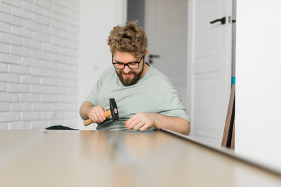 Portrait of woman using mobile phone while sitting on table