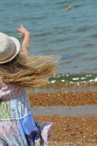 Rear view of woman in water at beach