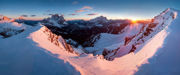 Panoramic view of snow covered mountains against sky during sunset