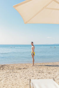 Rear view of man standing at beach