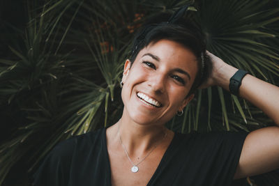 Portrait of smiling woman by plant