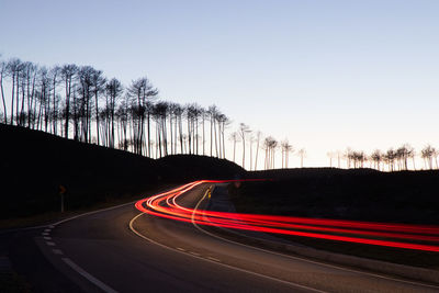 Light trails on road against sky in city