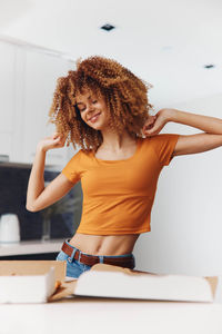 Rear view of young woman standing against wall