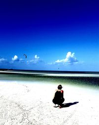 Man on beach against blue sky