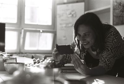 Young woman photographing with smart phone