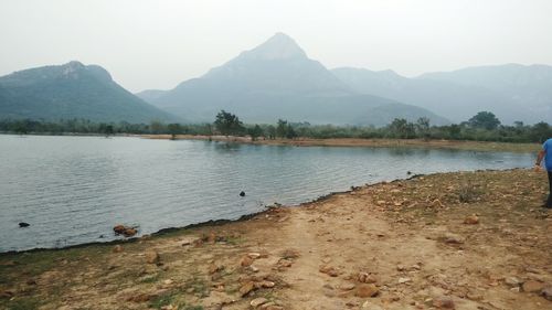 Scenic view of lake by mountains against sky