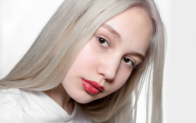 Close-up portrait of girl against white background