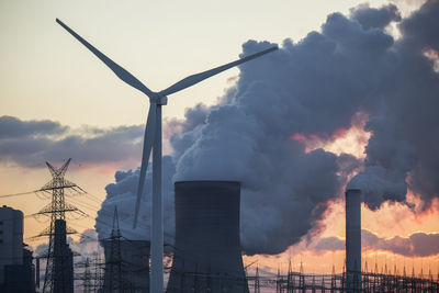 Germany, north rhine westphalia, niederaussem, wind turbines and lignite power station at sunset