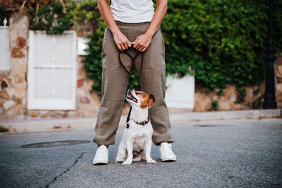 Low section of woman with dog on street