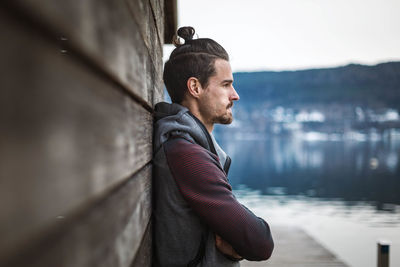 Side view of young man looking away while standing in water