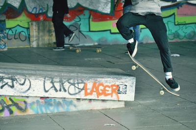 Low section of man skateboarding on skateboard in city