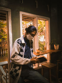 Man using mobile phone while sitting on table