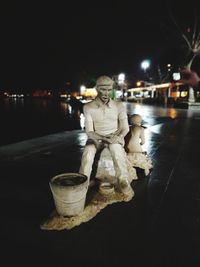 Illuminated statue on street in city at night