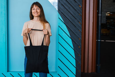 Woman holding black canvas tote bag. bag mockup for design.