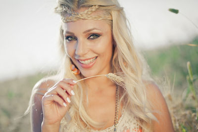 Portrait of beautiful woman with braided hair holding crop on field