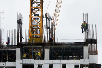 Low angle view of crane against sky