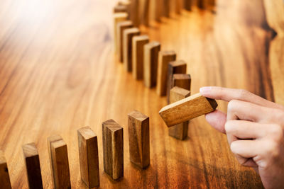 Cropped image of hand holding wooden blocks at table