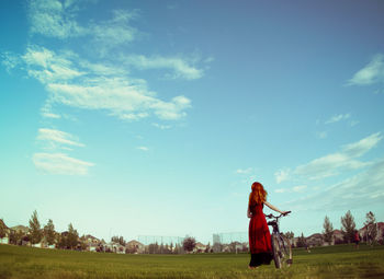 Woman standing on field against sky