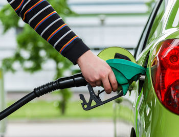Cropped hand of person refueling car