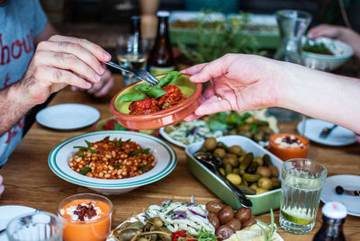 Cropped image of person passing plate to friend