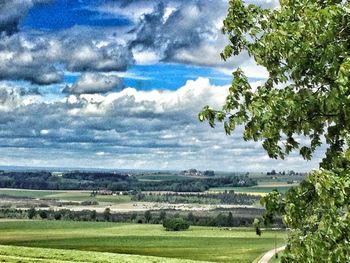 Scenic view of field against cloudy sky