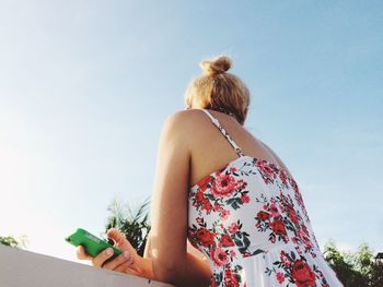 Low angle view of woman standing against sky