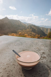 Cropped hand of woman holding coffee on mountain