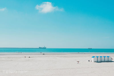 Scenic view of beach against blue sky