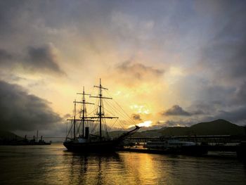 Sailboats sailing in sea against sky during sunset