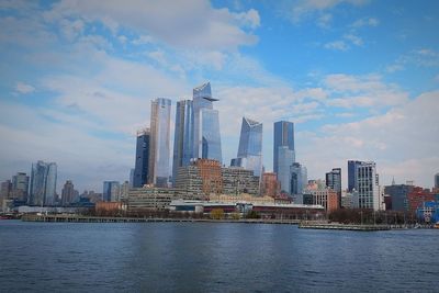 Modern buildings in city against cloudy sky