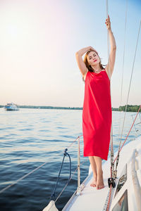 Beautiful woman relaxing on the nose of the yacht at a sunny summer day